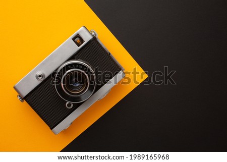 Photo camera on a yellow and black background with a place for your inscription. High quality photo