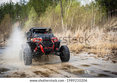 Cool view on hard ride UTV in muddy water Royalty-Free Stock Photo #1989210206