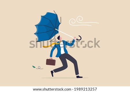 Business difficulty or obstacle in economic crisis, mistake or accident causing problem or failure, depressed and anxiety concept, frustrated businessman holding broken umbrella in strong wind storm. Royalty-Free Stock Photo #1989213257