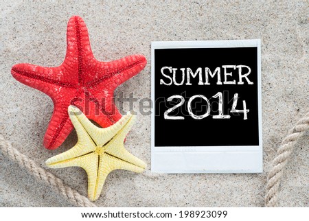 Summer 2014 handwritten with white chalk on photo and starfishes on sand
