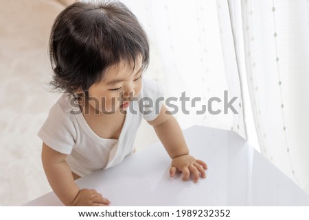 Baby standing at a table (0 years old, 10 months old, Japanese, girl) Royalty-Free Stock Photo #1989232352