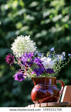 Little bouquet of simple garden flowers in a ceramic jug