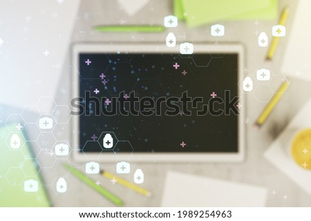 Double exposure of creative abstract medical hologram and digital tablet on background, top view. Healthcare technolody concept
