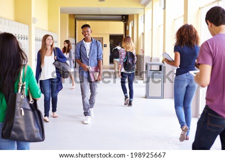 Group Of High School Students Walking Along Hallway Royalty-Free Stock Photo #198925667