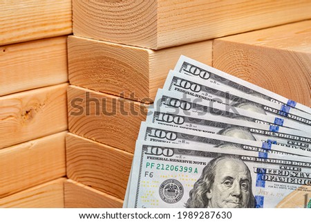 Construction lumber with cash money. Building materials price increase, home construction and remodeling cost concept. Royalty-Free Stock Photo #1989287630
