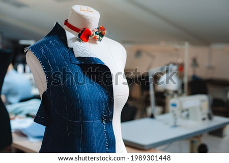 Fashion creative design studio interior concept with mannequin dummy and stylish fashionable trendy clothes on hangers, dressmaking workplace, tailor shop, sewing workshop Royalty-Free Stock Photo #1989301448