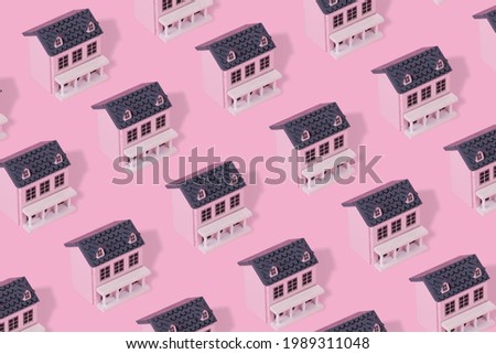 Modern pattern made with pink wooden house on a pastel pink background. Minimal creative concept.