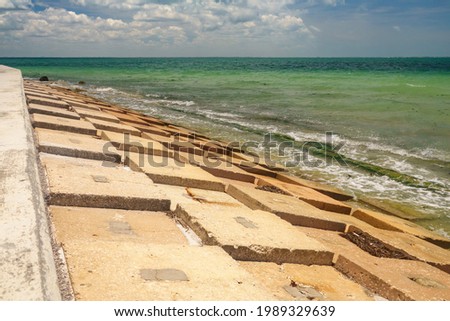 Geometric concrete revetment between low seawall and the Gulf of Mexico at the edge of a county park in west central Florida, for coastal and environmental themes Royalty-Free Stock Photo #1989329639