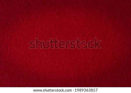 Felt texture with vignetting effect as a background, dark red color.