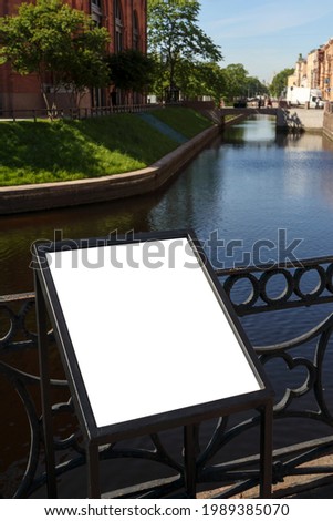 Blank white mock-up with metal frame on the canal walkway.