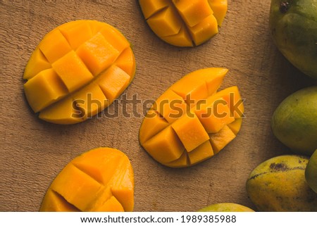Alphonso mango slices on wooden background stock image with selective focus.