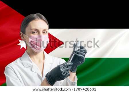 Girl doctor prepares vaccination against the background of the Jordan flag. Vaccination concept Jordan.