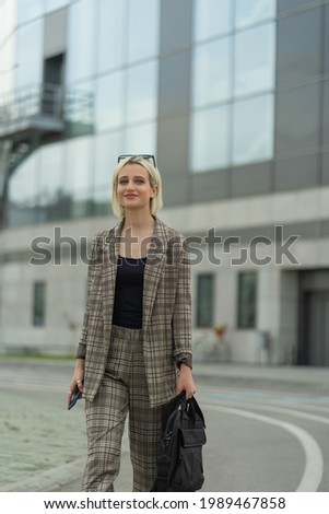 Beautiful businesswoman is smiling while walking towards the company