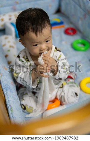 Portrait image adorable and cute happy Asian Chinese baby boy playing alone