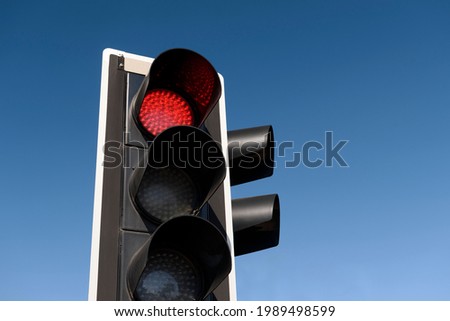 Traffic light with red light against the evening sky.