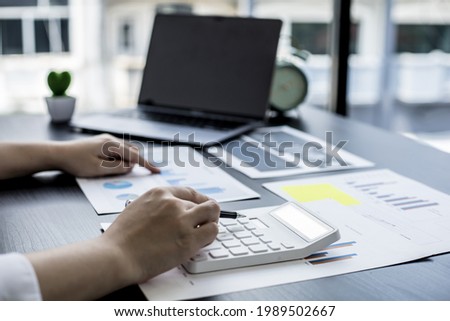 The head sales department checks the monthly sales datasheet for the salesperson to calculate the monthly commission, she looks at the document and presses the calculator. Sales management concept Royalty-Free Stock Photo #1989502667