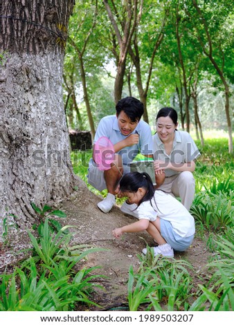 A happy family of three catches insects outdoors high quality photo