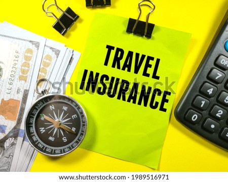 Business concept.Text TRAVEL INSURANCE on sticky note on notebook with calculator,banknote,compass and paper clips on yellow background.