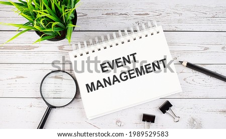 EVENT MANAGEMENT text concept write on notebook with office tools on wooden background