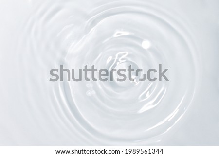serum or cosmetic liquid drops falling on water surface background