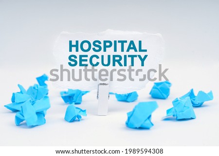 Medicine and health concept. On a white background, there are blue pieces of paper and a clothespin with paper on which it is written - HOSPITAL SECURITY