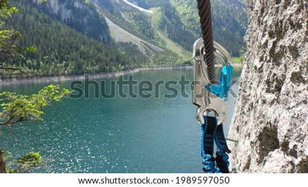Snap hook on steel rope in via ferrata in Austria Royalty-Free Stock Photo #1989597050