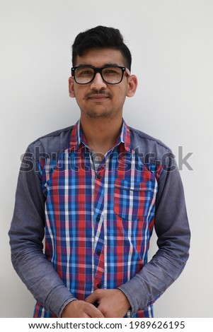 Indian nerd boy wearing eye spectacles looking at camera and hands folded in isolated white background.