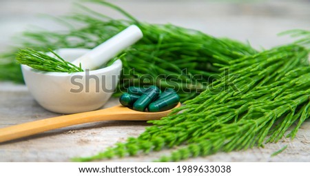 Horsetail pills homeopathy on a wooden spoon. Selective focus. Nature, Royalty-Free Stock Photo #1989633038