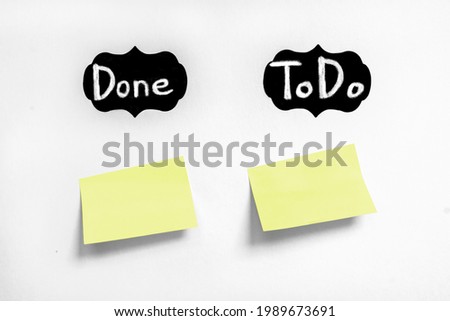 Chalk text Do and ToDo on black labels. Yellow sticker without any text on white Whatman paper. Concept learning, starting education. Handwriting text close up isolated, copy space. Royalty-Free Stock Photo #1989673691
