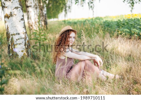 Red hair young girl in the field of summer