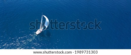 Aerial drone ultra wide panoramic photo of beautiful sail boat with white sails cruising deep blue sea near Mediterranean destination port Royalty-Free Stock Photo #1989731303