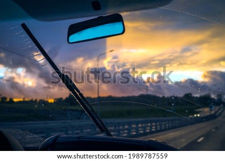 Windscreen wiper drives away the water. View from inside the car Royalty-Free Stock Photo #1989787559