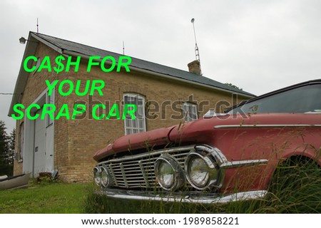 An old school with " Cash For Your Scrap Car' printed over it for a wrecking yard or an auto wrecking business advertisement. An old car sits beside. Royalty-Free Stock Photo #1989858221