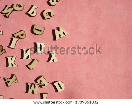 wooden letters of the English alphabet on pink suede as a background. High quality photo