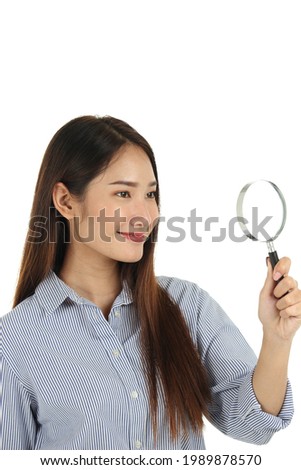 Portrait of young beautiful Asian woman with long dark brown hair holding magnifying glass isolated on white background.