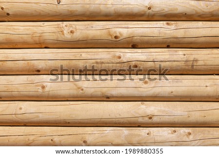 Modern, new, clean log wall made of round logs of natural color. Background image, texture
