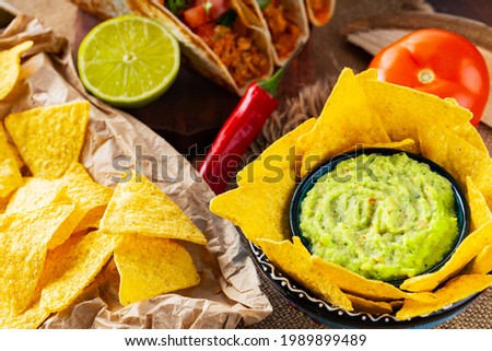 Mexican food table with nachos, guacamole, tacos and ingredients. Mexican taco and nacho tortilla chips on wooden boards. Hispanic mexican food