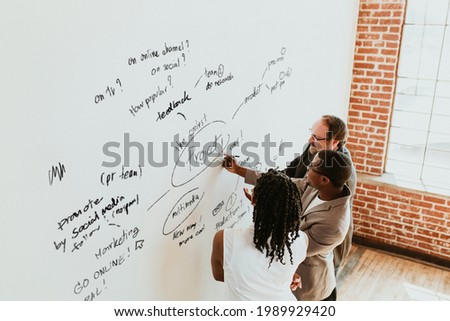 Business people writing on a whiteboard mockup Royalty-Free Stock Photo #1989929420