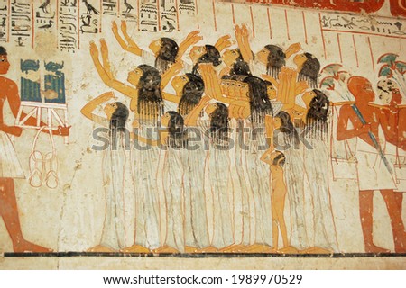 Ancient Egyptian mural showing women mourning at a funeral procession.  Tomb of the ancient Egyptian Vizier Ramose in the Sheikh Abd el-Qurna, part of the Theban Necropolis. Royalty-Free Stock Photo #1989970529