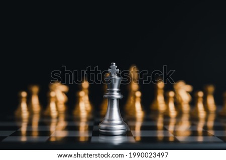 Silver king winner surrounded with silver chess pieces on chess board game competition.concept strategy, leadership and success business.
