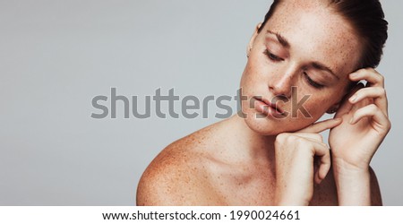 Close up of woman with freckles on body. Portrait of woman showing her beautiful freckles. Royalty-Free Stock Photo #1990024661