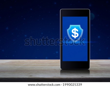 Dollar with shield flat icon on modern smart mobile phone screen on wooden table over fantasy night sky and moon, Business money insurance and protection online concept