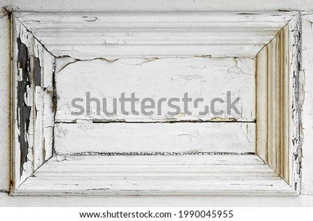 Heavily cracked paint on a white wooden door panel Royalty-Free Stock Photo #1990045955