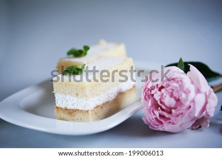 vanilla white cake with mint leaves on top and pink flower