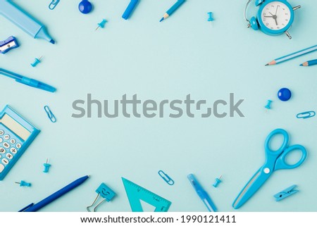 Top view photo of school supplies blue stationery on isolated pastel blue background with copyspace in the middle