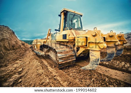 close-up of bulldozer or excavator working with soil on highway construction site  Royalty-Free Stock Photo #199014602