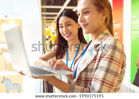 Portrait of Asian Woman Smiling Charmingly while Standing in walkway office. Portrait Of Successful Business Woman with laptop,startup small business concept in modern office.