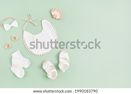 Mockup of empty frame with white baby accessories. Baby shower, baptism invitation