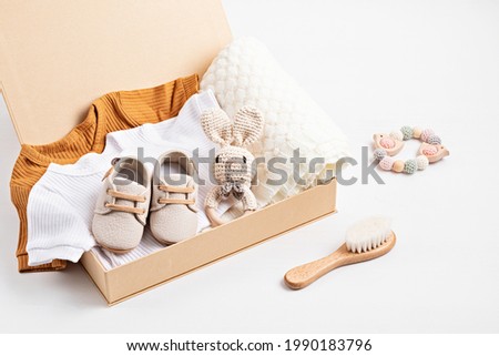 Gift basket with gender neutral baby garment and accessories. Care box of organic newborn cotton clothes Royalty-Free Stock Photo #1990183796
