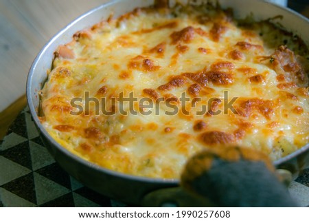 Closeup of Frittata (gratin) in an hot iron pan plate, Italian food, a dish combination of cheese, ham, egg and meat then cook in the oven. Royalty-Free Stock Photo #1990257608